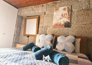 テーラス・デ・ボウロにあるMyStay - Casa do Cabeço de Boi by Refúgio ao Luarの青い枕が付いたベッドのある寝室