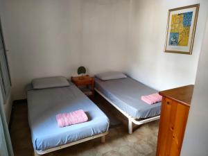 a room with two beds and a table with a night stand at OLMETA DI TUDA - T3 in Olmeta-di-Tuda