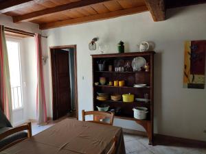 a dining room with a table and a shelf with dishes at OLMETA DI TUDA - T3 in Olmeta-di-Tuda +10 photos