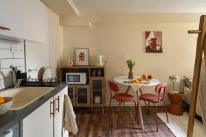 a kitchen with a table and chairs in a kitchen at Dotan's Boutique Studios - By Gordon Beach! in Tel Aviv