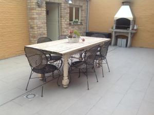 drewniany stół z krzesłami wokół niego na patio w obiekcie Vakantiewoning Ijzerrust w mieście Roesbrugge-Haringe