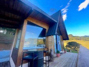 a house with a deck with a view of the water at Chalé de Luxo em Paulo Lopes in Paulo Lopes