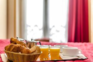 un cesto di pane e due bicchieri di succo d'arancia. di Avenir Hotel Montmartre a Parigi