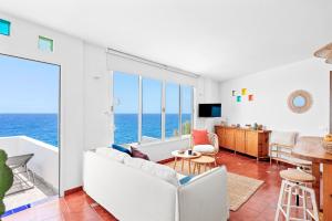 a living room with a white couch and a view of the ocean at Canary casita next to the Atlantic Ocean in Radazul