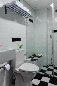 a bathroom with a toilet and a sink and a shower at The New Port Hotel TLV in Tel Aviv