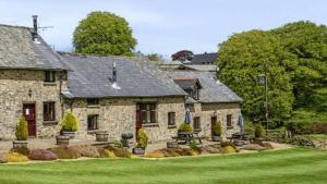 a large stone house with a green lawn at Kiri - Charming Cottage Perfect for Large Groups & Family in Dulverton