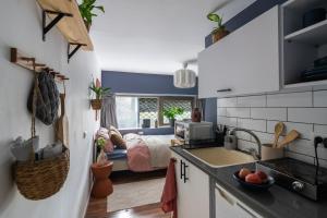 a kitchen with a sink and a bed in a room at Dotan's Boutique Studios - By Gordon Beach! in Tel Aviv +20 photos
