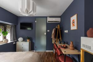a bedroom with blue walls and a desk and a bed at Dotan's Boutique Studios - By Gordon Beach! in Tel Aviv