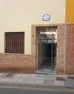 an entrance to a brick building with a glass door at Apartamento Turístico La Clase in La Zubia
