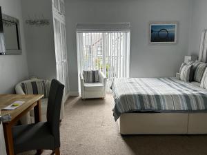 a bedroom with a bed and a chair and a table at Wenden Guest House in Newquay