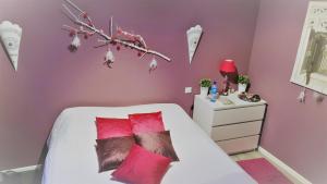 a bedroom with pink walls and a bed with red pillows at Villa CLOTESS in Dompierre-sur-Mer +14 photos