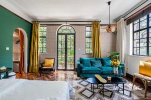 a bedroom with a bed and a blue couch at Shanghai Century Old House Downtown B&B in Shanghai