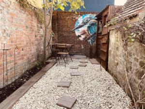 une cour avec une table et un mur avec une fresque dans l'établissement Charming Cottage Sleeps 4 with Sauna, à Shaftesbury