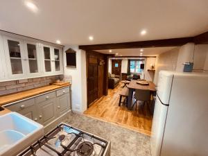 une cuisine avec un réfrigérateur blanc et une table dans l'établissement Charming Cottage Sleeps 4 with Sauna, à Shaftesbury