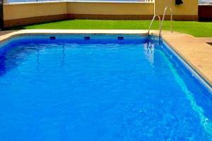 a large pool with blue water in a yard at KS Maral Home - Kaleria Suites in Aguadulce