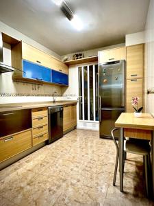 a kitchen with wooden cabinets and a stainless steel refrigerator at KS Maral Home - Kaleria Suites in Aguadulce