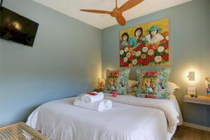 Un dormitorio con dos camas con un cuadro en la pared. en Pearl Moon Boutique Suites, en Wilderness