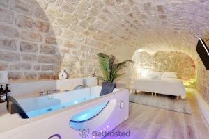y baño con bañera en una pared de piedra. en Charming flat with Jacuzzi heart of Paris GetHosted, en París