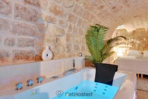 bañera en una habitación con pared de piedra en Charming flat with Jacuzzi heart of Paris GetHosted, en París