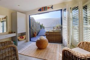 a room with a large window with a vase on the floor at Pearl Moon Boutique Suites in Wilderness