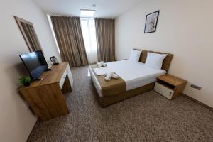a hotel room with a bed and a television at City Plaza in Botevgrad