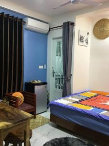 Phumĭ Ta PhŭlにあるKitya Homestayのベッドルーム1室(ベッド1台、テーブル、ドア付)