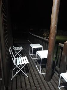 two chairs and tables on a deck at night at Zero-Three Vaal Ultimate Sky in Vanderbijlpark