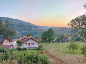 una casa en un campo con la puesta de sol en el fondo en Esma, en Sarajevo