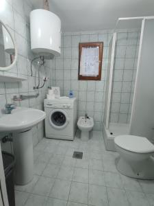 Un baño con lavadora y un inodoro. en Esma, en Sarajevo