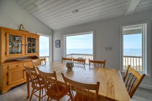 a dining room with a wooden table and chairs at Oceanfront - Pool - Luxury North Topsail Beach House in West Onslow Beach
