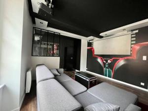 a living room with a couch and some red seats at Le Moovie - Centre-ville- Écran cinéma in Sens