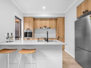 a kitchen with white countertops and wooden cabinets at New Central 2 bedroom townhouse in Beechworth