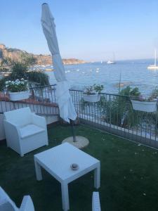 un patio con un tavolo, una sedia e un ombrellone di Home & Sea a Giardini Naxos