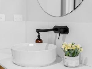 lavabo en el baño con una botella de vino y flores en Brand new 3 bed townhouse walk to town, en Beechworth 8 fotos más