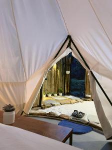 マックトシュワーにあるBell Glamping Mukteshwarのベッドとテーブルが備わったテント