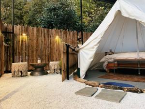 a tent with a bed and a fence at Bell Glamping by The HULYA since 2021 in Mukteshwar