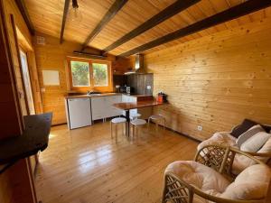 a room with a kitchen and a table in a cabin at Casa em madeira com jardim privado in Peniche