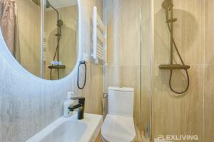 ein Badezimmer mit Toilette, Waschbecken und Spiegel in der Unterkunft Flexliving - room - Neuilly-sur-Seine in Neuilly-sur-Seine + 3 Fotos