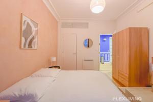 - une chambre avec un grand lit blanc et une armoire dans l'établissement Flexliving - room - Neuilly-sur-Seine, à Neuilly-sur-Seine