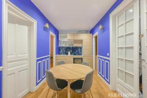une salle à manger avec des murs bleus et une table et des chaises dans l'établissement Flexliving - room - Neuilly-sur-Seine, à Neuilly-sur-Seine