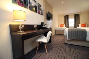a hotel room with a desk and a bed at Palette Modern Newport City Center in Newport +12 photos