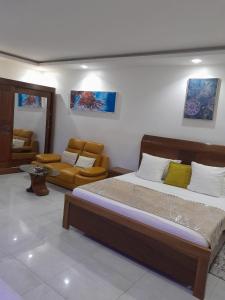 Un dormitorio con una cama y una sala de estar. en Résidence Acky, en Dakar 124 fotos más