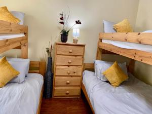 a bedroom with two bunk beds and a dresser at Grand Isle Unit E pet friendly detached condo 3 bedrooms 1 bath easy beach access in Grand Isle