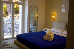 a hotel room with a bed with towels on it at Eden affittacamere in Cala Gonone +7 photos