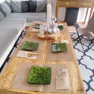 a coffee table with green plates on top of it at Riad Laila Marrakech in Marrakesh