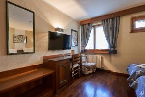 a hotel room with a desk and a television at Hotel Walser Courmayeur in Courmayeur
