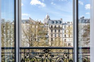 ein Fenster mit Blick auf ein Gebäude in der Unterkunft Avenir Hotel Montmartre in Paris