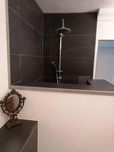 a black bathroom with a sink and a mirror at Gemütliche Wohnung Rothaarsteig Ski Sauna Ruhrtal Green Hill in Schmallenberg