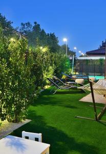 a yard with green grass and chairs and a pool at Charming Home with Pool and Garden, Just Outside Madrid in Villanueva de la Cañada