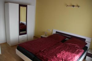 a bedroom with a red bed and a mirror at Ferienwohnung Neuber in Bad Kissingen
